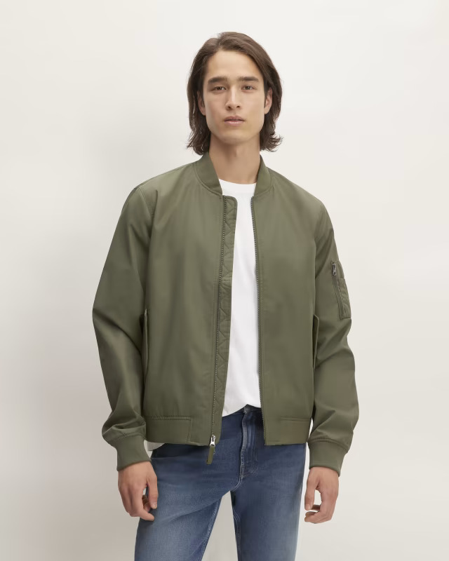 Kalamata olive colored bomber jacket with two-way zipper and magnetic closure pockets.